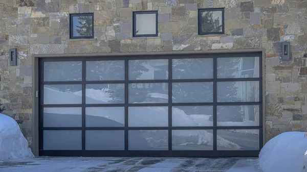 Casa Pano con muro in pietra e porta del garage in vetro vista durante l'inverno a Park City — Foto Stock