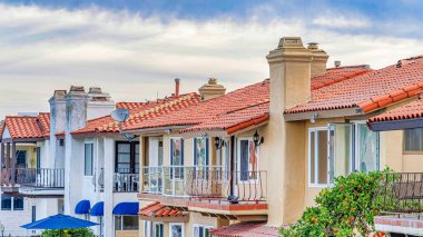 Mavi gökyüzüne ve parlak bulutlara karşı balkonlu ve verandalı Pano Rıhtım evleri