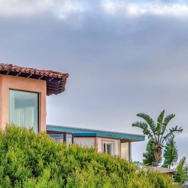 Balkon kiremit çatılı kare ev ve San Diego 'da gökyüzü arka planlı şeftali duvar.
