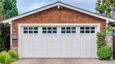 San Diego California 'daki Pano Garajı' nın çatısının altında beyaz kapısı ve kahverengi duvarı var.