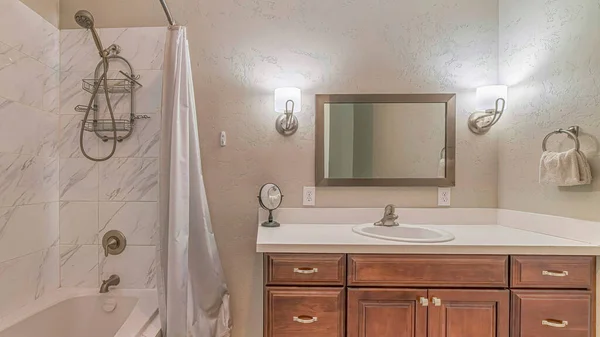 Pano Раковина над шкафами и построен в ванной с душем внутри ванной комнаты дома — стоковое фото