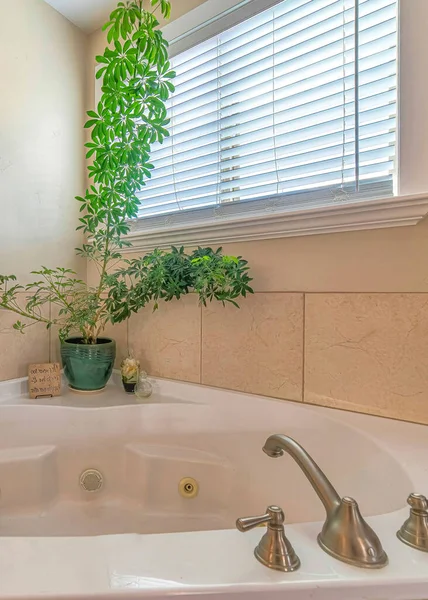 Вертикально отполированный белый, встроенный в ванну со стальной решеткой в углу ванной комнаты — стоковое фото