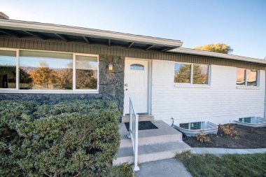 Evin dışı beyaz kapılı, taşlı ve tuğladan duvarlı.