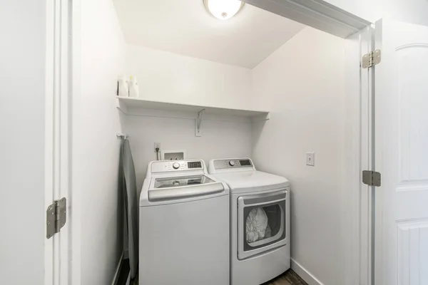 Pequeno armário de lavandaria com tábua de engomar dobrada e porta dupla — Fotografia de Stock