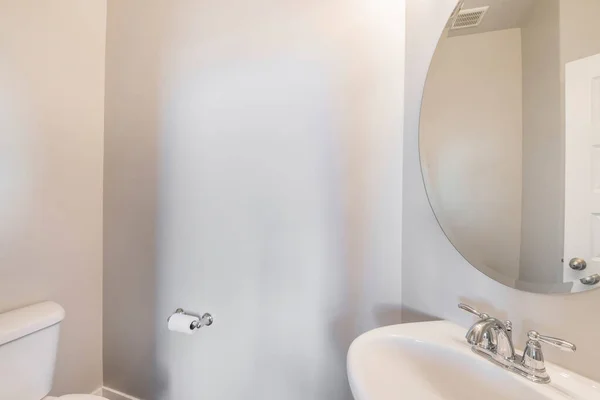 洗澡间的白色墙壁，水池上方有一个巨大的椭圆形镜子 — 图库照片