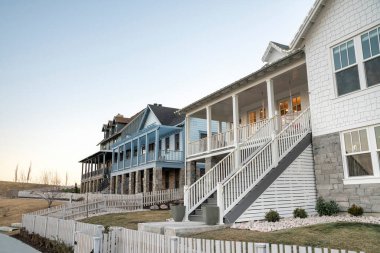 Yükseltilmiş verandaları ve ön bahçeleri olan lüks evler.