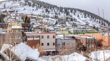 Utah 'taki Park City' de karla kaplı bir tepede Pano Renkli evler ve binalar.