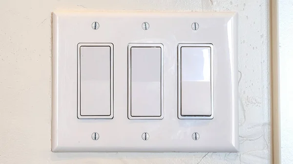 Світловий вимикач Pano Rocker з декількома плоскими широкими важелями, встановленими на внутрішній стіні — стокове фото