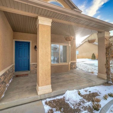 Kare çerçeve Kışın karlı mahallede Koyun penceresi ve mavi menteşeli ön kapısı olan ev