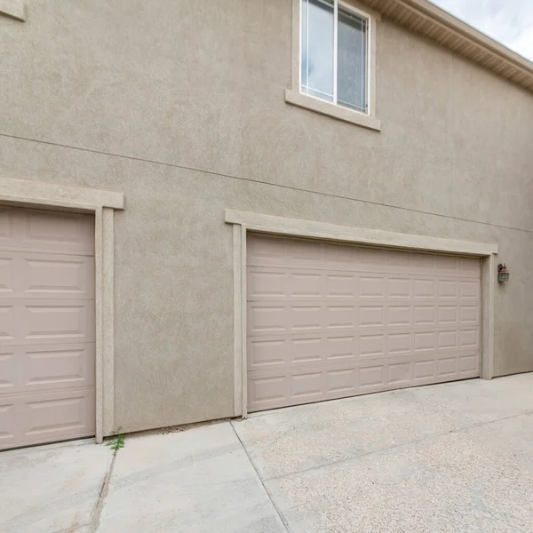 Square frame Exterior of two buildings with concrete driveway, garage doors and windows — Stock Photo, Image