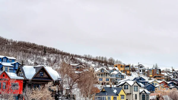Pano Ciudad de montaña en un paisaje nublado de invierno con casas en terreno de pendiente nevada — Foto de Stock