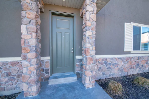 Exterior de la puerta delantera gris con revestimiento de pared de piedra y postes de columna — Foto de Stock