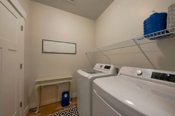 Interior da lavanderia com aparelhos de carga superior e unidade de prateleira de arame — Fotografia de Stock