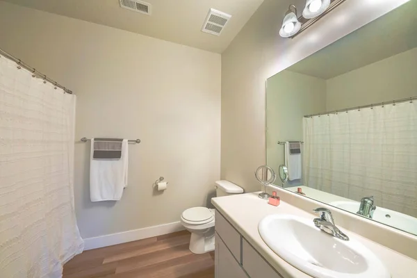 Interior de um banheiro branco limpo com piso de madeira de vinil — Fotografia de Stock