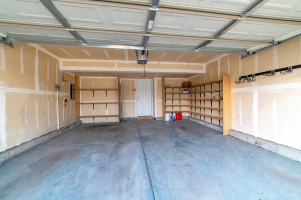 Интерьер гаража с белой линией разметки, деревянные полки и белая дверь — стоковое фото