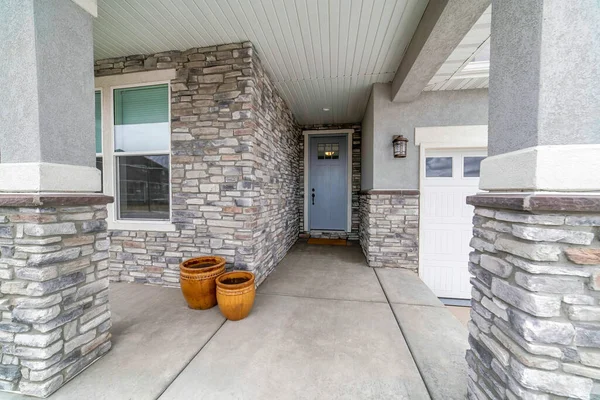 Front door exterior with stone veneer siding and concrete flooring — Stock Photo, Image