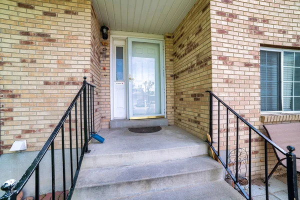 Front door of a house with bricks and metal railings — Stock Photo, Image