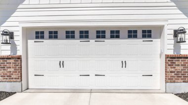 Pano Garaj girişi, her iki tarafında da duvar lambası var.