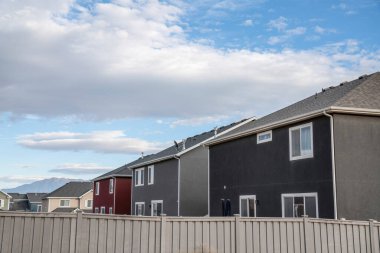 Önünde bej rengi vinil çit olan büyük konut evleri.