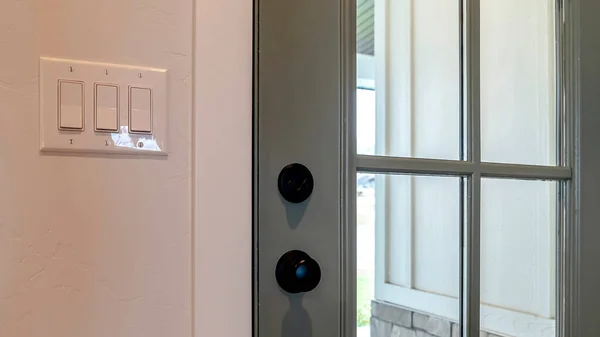 Pano Close up of wooden front door of home with glass panel and black doorknob — Stock fotografie