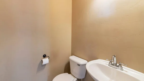Pano Порошковая комната с загорелыми стенами, унитазом и раковиной — стоковое фото