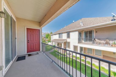 Kırmızı ahşap kapısı ve sürgülü kapısı olan bir evin verandası.