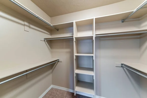 Pequeño vestidor vacío con estantes y varillas de metal — Foto de Stock