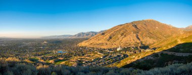 Panoramic view of Draper, Utah against the mountains and beautiful sky at the background clipart