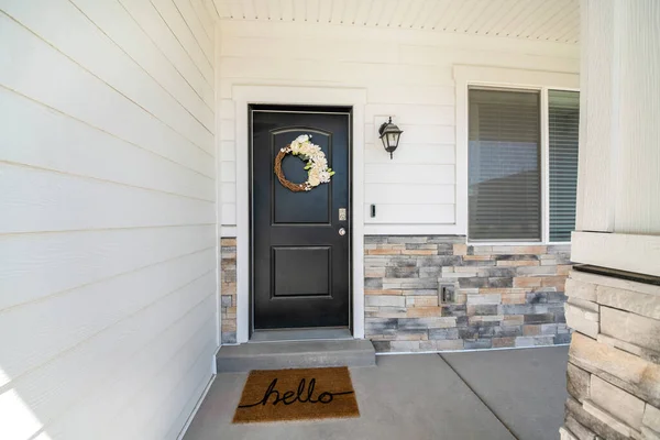 Black front door exterior with beautiful flower wreath decoration