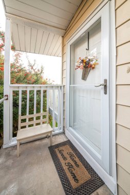 Cam fırtınalı bir evin ön girişi ve güzel bir ev paspası.