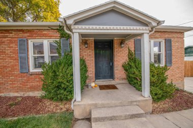 Cadılar Bayramı süslemeleri ve kilitli siyah ön kapısı olan bir evin girişi