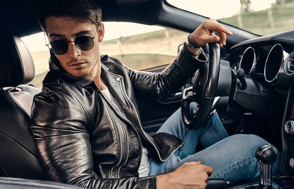 Joven Guapo Gafas Sol Ropa Casual Sentado Coche Deportivo Moderno — Foto de Stock