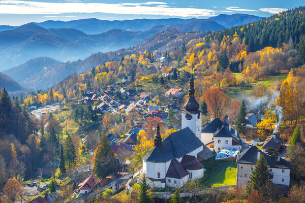 The Spania Dolina village with church and historic buildings in valley of autumn landscape, Slovakia, Europe.