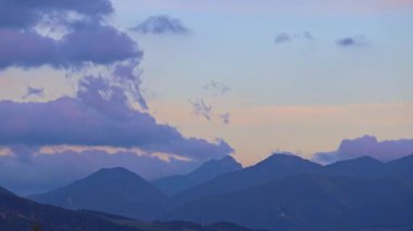 Dağlar gökyüzünü mavi ve mor renklerle karşılar. Bulutlar, alacakaranlıkta sakin manzaraya karşı çarpıcı bir kontrastlık yaratır. Slovakya, Avrupa 'daki Mala Fatra ulusal parkı. Zaman ayarlı görüntüler.