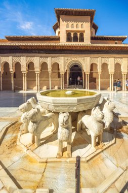 Granada, İspanya - 5 Eylül 2024: Aslanlar Mahkemesi ve Alhambra kompleksindeki merkez çeşmesi. Güneşli bir avluda aslan heykelleriyle süslü bir çeşme.
