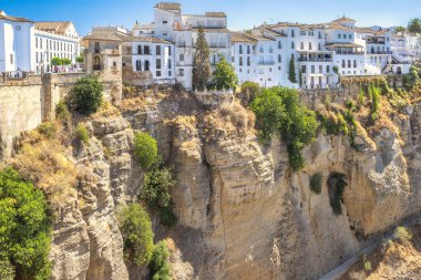 Ronda, İspanya - 4 Eylül 2024: Beyazlatılmış köy çarpıcı bir manzaraya bakan bir uçurumun kenarına tünedi.