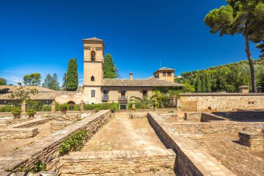 Granada, İspanya - 5 Eylül 2024: Alhambra kompleksindeki Aziz Francis Manastırı. Antik kalıntılar ve açık mavi gökyüzünün altında tarihi bir bina. Tarihi mimarinin sakin bir sahnesi..