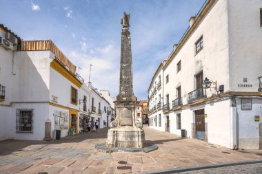 Cordoba, İspanya - 7 Eylül 2024 Plaza del Potro Meydanı. Parlak gökyüzünün altında beyaz binalarla çevrili uzun taş bir anıtı olan tarihi kasaba meydanı..