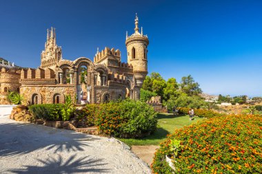 Benalmadena, İspanya - 6 Eylül 2024: Kristof Kolomb onuruna inşa edilen Castillo de Colomare kalesi. Güneşli bir günde canlı bir bahçeye kurulmuş taş kale..