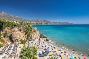 Nerja, İspanya - 9 Eylül 2024: Europa Meydanı 'ndan görüntü. Turkuaz suyu ve dramatik uçurumları olan kalabalık bir plaj..