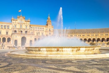 Seville, İspanya - 8 Eylül 2024: İspanya 'nın başkenti Endülüs' teki Plaza de Espana Meydanı. Güneşli bir meydanda büyük bir çeşme. Bölgeyi saran tarihi binalar var..
