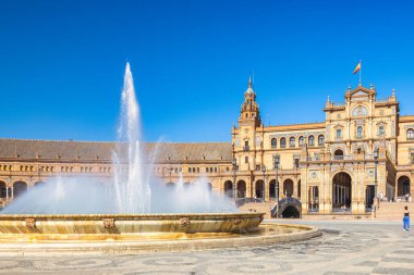 Seville, İspanya - 8 Eylül 2024: İspanya 'nın başkenti Endülüs' teki Plaza de Espana Meydanı. Açık mavi gökyüzünün altında tarihi mimarisi olan Grand Plaza çeşmesi..
