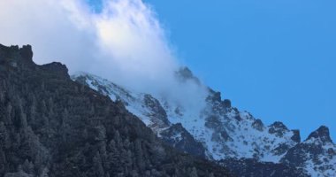 Görkemli bir dağ sırası gökyüzünü delip geçer. Kayalık tepeleri ve yamaçları karla kaplanırken bir orman tabanına yapışır. Görülmeye değer bir manzara. Yüksek Tatras Ulusal Parkı, Slovakya, Avrupa.