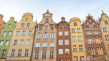 Gdansk, Polonya - 1 Mayıs 2025: Dekoratif cepheli, çok sayıda pencereli ve renkli dış görünüşlü çeşitli mimari tarzlar sergileyen eski binalar.