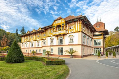 Luhacovice, Çek Cumhuriyeti - 21 Ekim 2024: Jurkovic House in the spa town. Zarif bir mimari kremalı ve süslü, altın aksanlı parlak, bulutlu gökyüzü altında parlıyor..