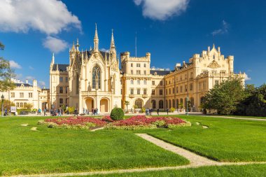 Lednice, Çek Cumhuriyeti - 12 Ekim 2024 Lednice Kalesi. Geniş bir bahçesi olan, güneşli bir öğleden sonra açık mavi gökyüzünün altında yürüyen bir şatonun panoramik manzarası..