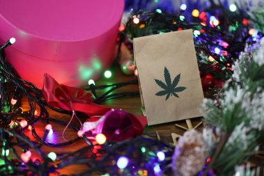 Yeni yıl süsleri, hediyeler, çelenkler arasında masada marihuana dolu kağıt torba yatıyor.