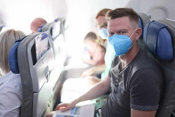 Família em máscaras de proteção médica estão sentados na cabine de avião. — Fotografia de Stock