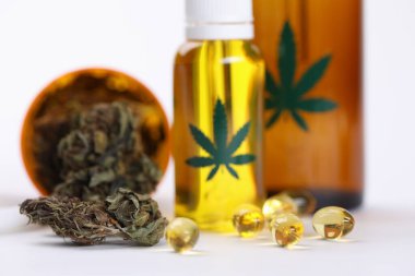 Kurumuş yapraklar, marihuana kapsülleri eczanede yakın planda yatıyor.