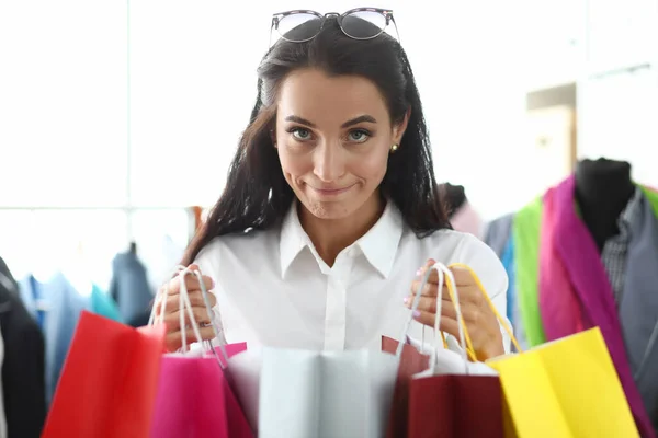 Portret van jonge mooie vrouw met veelkleurige tassen met aankopen in de winkel — Stockfoto